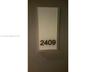 Wall-mounted unit identifier featuring a rectangular opaque panel with contrast lettering
