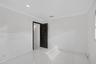Interior room featuring large-format tile flooring, crown molding, recessed lighting, and a six-panel dark wood-finish door