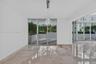 Polished stone flooring, floor-to-ceiling glass sliding doors, built-in contemporary pendant lighting, and an expansive exterior terrace with masonry 