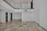 Interior space featuring high ceilings, polished stone flooring, a glass-panel mezzanine railing, recessed lighting, and multi-panel doors