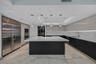 Modern kitchen featuring a central island with a stone countertop, high-gloss cabinetry, stainless steel refrigerator, recessed ceiling lighting, and 
