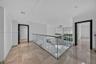 Polished tile flooring, glass panel railing with a metal handrail, recessed lighting, and dark-toned door frames
