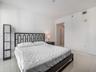 Neutral-toned interior space featuring light-colored polished tile flooring and crisp white wall finishes