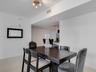 Neutral-toned tile flooring, recessed architectural soffit, and multi-light ceiling fixture