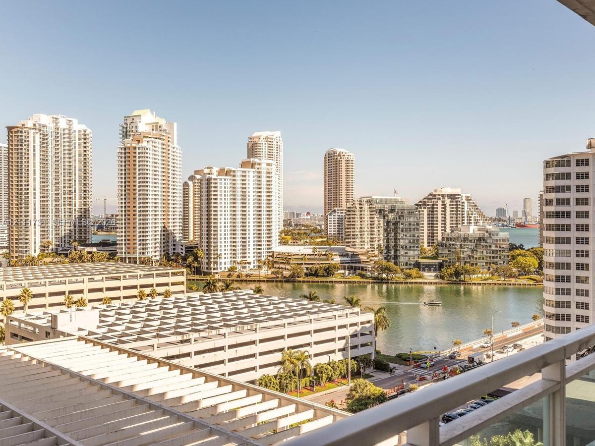 High-rise balcony with metal railings, offering an elevated perspective of the urban skyline, waterfront, and surrounding cityscape