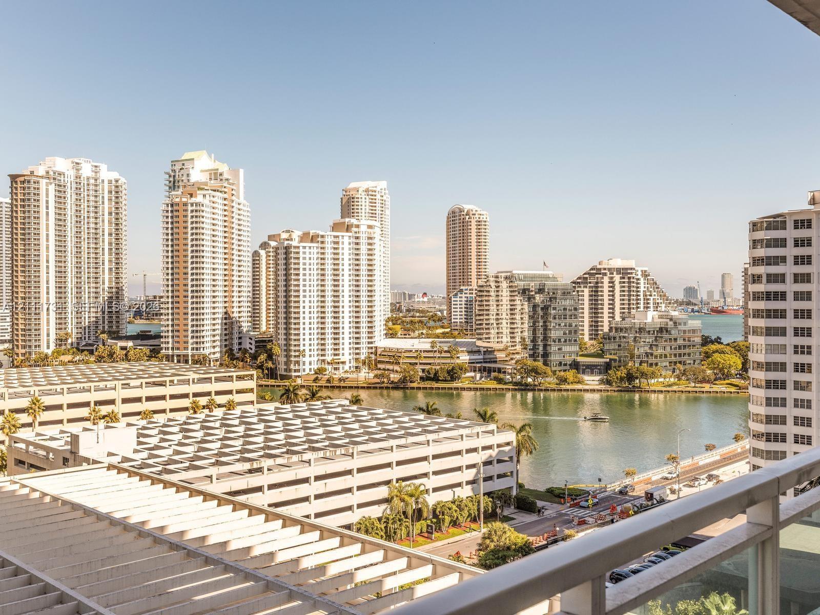 High-rise balcony with metal railings, offering an elevated perspective of the urban skyline, waterfront, and surrounding cityscape