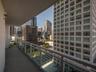 Covered balcony featuring concrete flooring and a transparent glass panel railing with metallic frame accents