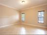 Neutral-toned room featuring diagonal tile flooring, crown molding, and two windows with horizontal blinds
