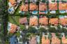 Aerial perspective of a residential property featuring a clay tile roof, a paved driveway, and mature landscaping