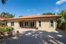Stucco exterior featuring a terracotta tile roof, paver patio, and multiple sets of French doors