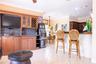 Built-in cabinetry featuring glass-front display panels and wine storage, stone-surfaced bar counter with textured stone base, and tiled flooring