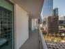 Private balcony featuring concrete flooring, full-height glass panel railings, and access through sliding glass doors