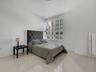 Large-format tile flooring, expansive multi-pane window, and neutral wall palette