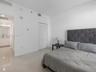 Polished tile flooring, neutral wall finishes, and closet with white louvered doors