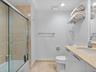Bathroom featuring a glass-enclosed shower with tiled surround, stone countertop, white vanity cabinetry with chrome hardware, and recessed lighting