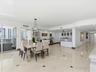 Open-concept area featuring polished stone flooring with decorative inlays, a built-in wet bar with cabinetry, recessed lighting, a modern multi-arm c