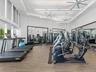 Fitness center featuring wood-finish flooring, floor-to-ceiling mirrored walls, recessed linear lighting, and ceiling-mounted fans