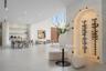 Arched, climate-controlled glass wine display with integrated accent lighting, built-in shelving, smooth plaster wall finishes, recessed ceiling light