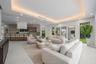 Open-concept interior featuring a recessed tray ceiling with integrated cove lighting, polished concrete flooring, built-in floor-to-ceiling cabinetry