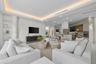 Open-concept interior featuring a recessed tray ceiling with integrated cove lighting, textured wall finish, built-in display shelving, and custom cab