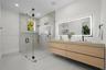 Floating dual-sink vanity with light wood cabinetry and solid-surface countertop, frameless glass walk-in shower with stone tile surround, integrated 