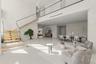 Open-concept interior featuring a floating staircase with wood treads and glass railings, polished concrete flooring, a custom arched wall niche, and 