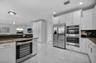 Kitchen featuring white shaker-style cabinetry, stainless steel side-by-side refrigerator, built-in double wall oven, integrated wine refrigerator, an