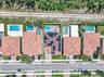 Aerial perspective of property featuring a tile roof with integrated solar panels, private swimming pool, spa, and paved rear patio