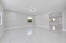 Large-format tile flooring, recessed lighting, archway architectural detailing, and neutral wall tones