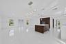 Open-concept interior featuring large-format tile flooring, a center island with a stone countertop, dark wood-finish cabinetry, recessed lighting, an