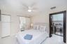 Sliding barn-style door, ceiling fan with integrated lighting, polished flooring, and a dedicated laundry area featuring built-in cabinetry and stainl