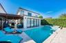 Stucco exterior with multi-panel sliding glass doors, covered patio structure, tiled pool, and raised spa with mosaic tile accents