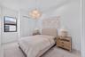 Minimalist interior featuring neutral-toned tile flooring, double-door closet with recessed handles, and a sculptural pendant light fixture