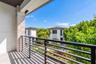 Covered balcony featuring stacked-stone pillar detailing, horizontal metal railing, and smooth-surface flooring