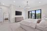 Neutral-toned tile flooring, recessed ceiling lighting, contemporary pendant fixture, and floor-to-ceiling sliding glass doors opening to a balcony wi