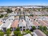 Aerial perspective featuring a two-story residence with a multi-hipped roofline, stucco exterior, and a built-in balcony