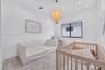 Neutral interior featuring a large window with black framing, recessed ceiling lighting, and a spherical pendant fixture