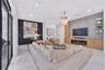 Living area featuring oversized floor-to-ceiling sliding glass doors, large-format tile flooring, a linear electric fireplace with wood-finish cabinet