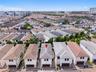 Aerial perspective of a multi-story residence featuring a hipped tile roof, white stucco exterior, integrated garage, and a compact private lot