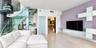 Floating glass staircase with metal structural supports, large-format tile flooring, built-in modular wall storage, and frosted glass paneled doors