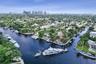 Aerial perspective of waterfront properties featuring deep-water canal access, private boat slips, concrete seawalls, and lush tropical landscaping