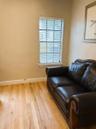 Wood-finish flooring paired with a single-pane window featuring horizontal blinds