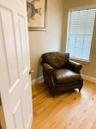 Wood-finish flooring, multi-pane window with adjustable slat blinds, and classic paneled interior door