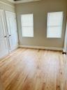 Interior space featuring wood-finish flooring, two dual-pane windows with fitted blinds, and two solid-core paneled doors