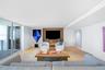 Living space featuring wood-finish flooring, floor-to-ceiling sliding glass doors, and a custom built-in wood media niche with recessed lighting