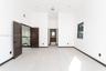 High-ceilinged room featuring large-format tile flooring, dark-toned interior doors, recessed lighting, and expansive window with dark framing