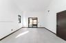 High-ceiling interior featuring large-format tile flooring, recessed lighting, dark-framed sliding glass doors, and a solid-core door with matte black