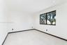Interior room featuring large-format tile flooring, crisp white walls, recessed ceiling lighting, and a single-pane window with a black frame