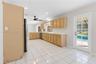 Kitchen featuring natural wood cabinetry, white countertops, ceramic tile flooring, recessed lighting, and a multi-lite door providing exterior access