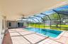 Screened-in lanai featuring a rectangular swimming pool, ceramic tile flooring, and multiple ceiling fans